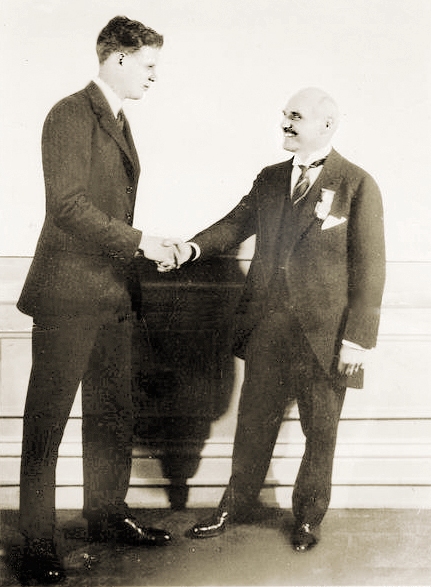 Raymond Orteig shaking hands with Charles Lindbergh.