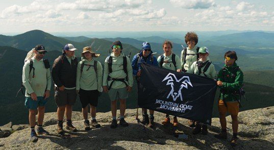 Eight boys standing on an overlook.