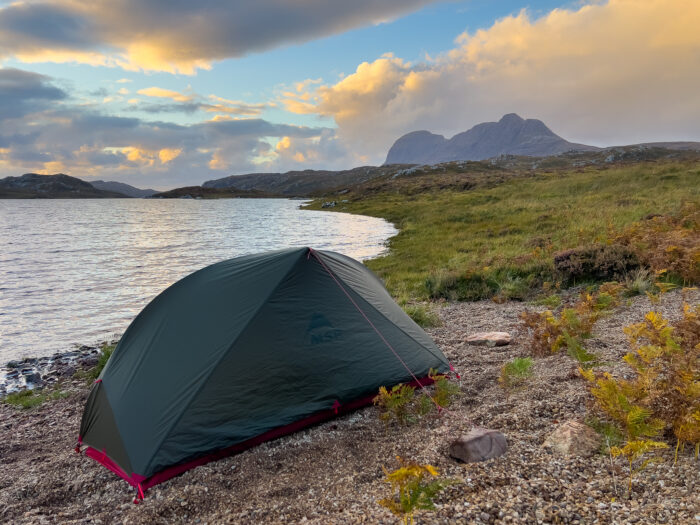A tent pitched on the shores of Loch Veyatie, with Suilven looming in the background