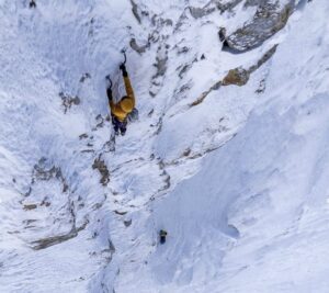 two climbers on a vertical ice face, alpine style.