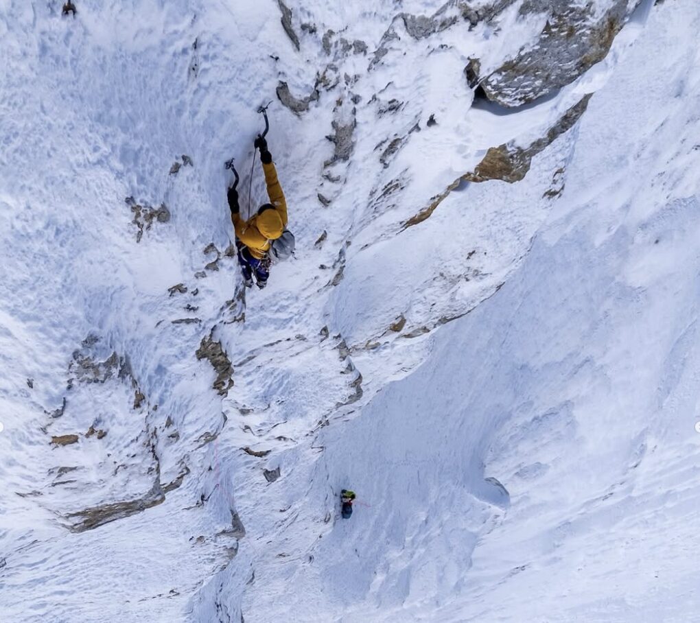 two climbers on a vertical ice face, alpine style.