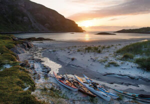 Kayaks rest on the coast of Sørøya.