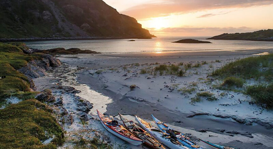 Kayaks rest on the coast of Sørøya.