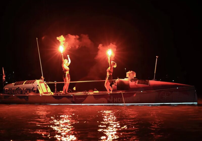 rowers light flares at night