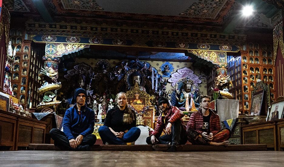 four guys sitting on the floor in a temple