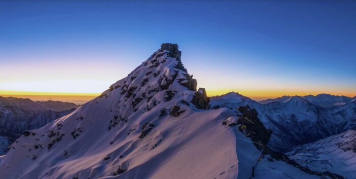 A spiky ridge of rock and snow in dim light.