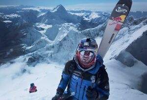 Close shot of Bargiel on Everest, Makalu behind him, with skis on his back.
