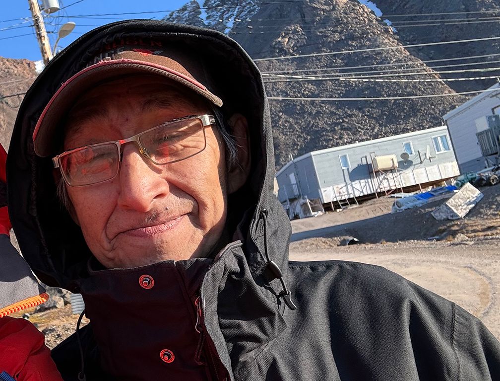 An older man in cold weather clothing, smiling