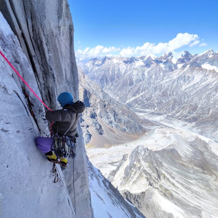 A climber on a vertical mized face.