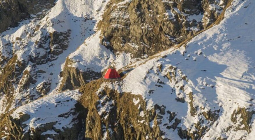 The bright red Frattini Bivouac sitting in the Italian Alps