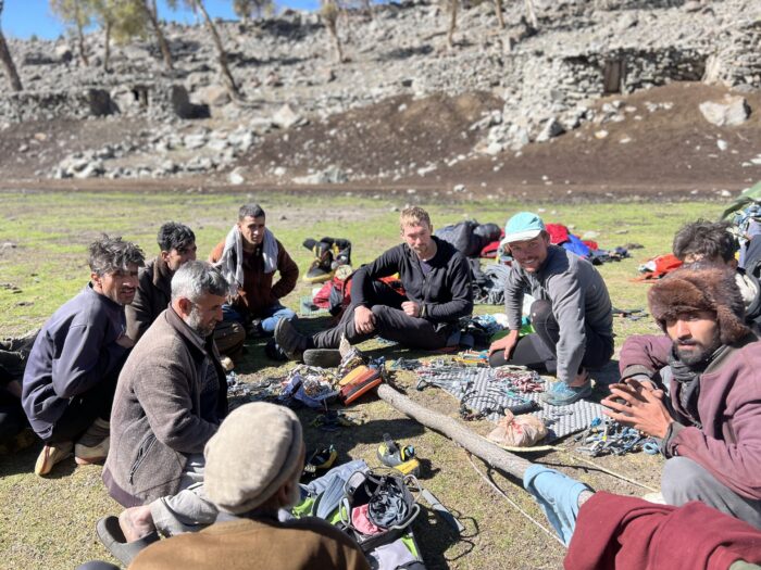 Two young british climbers at picnic with local shepherds ona sunny day.