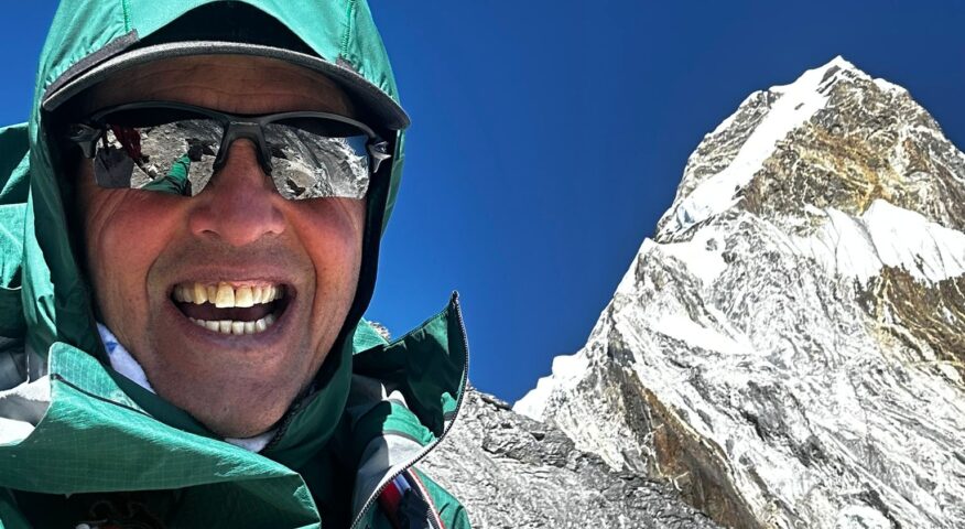 Simone Moro takes a selfie with the summit of Ama Dablam behind him.