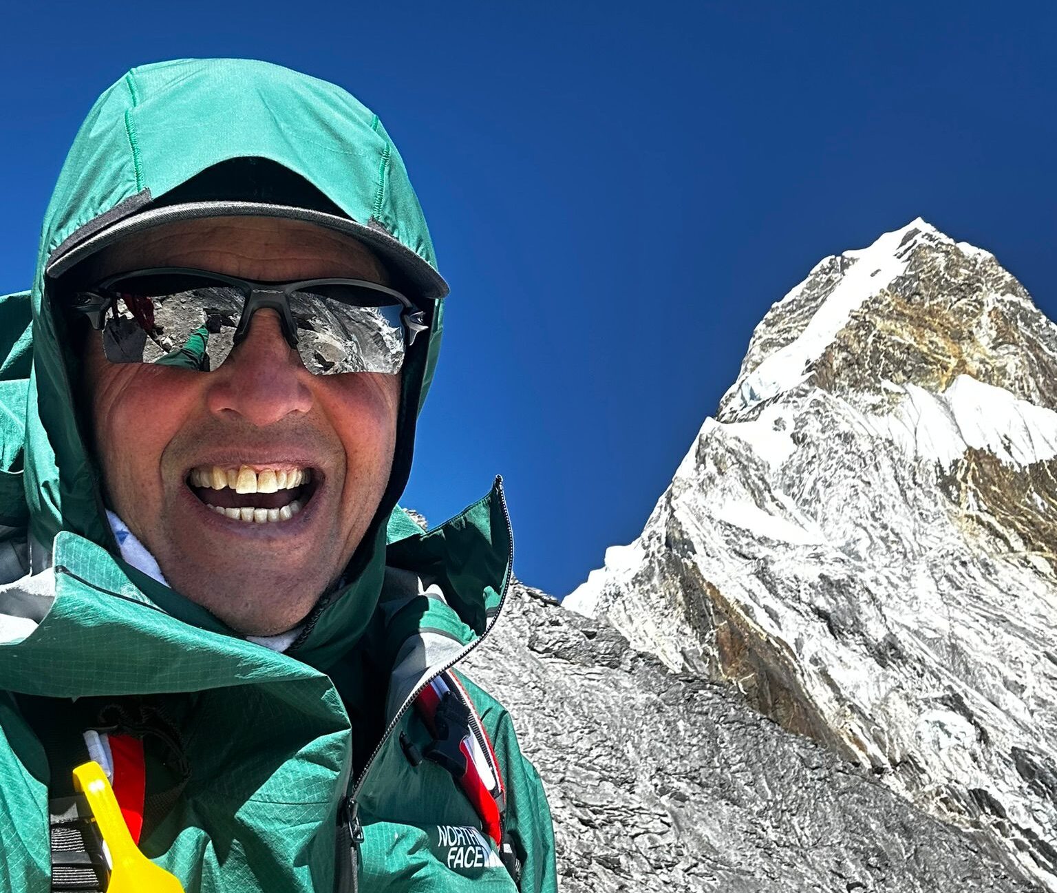 Simone Moro takes a selfie with the summit of Ama Dablam behind him.