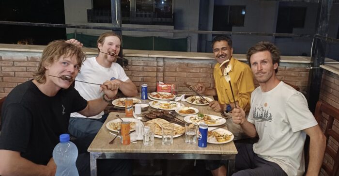 The climbers and operator eating kebabsat a rooftop restaurant.
