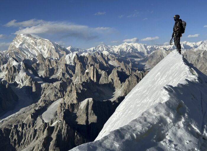 A man stands on an unnamed peak in Pakistan.