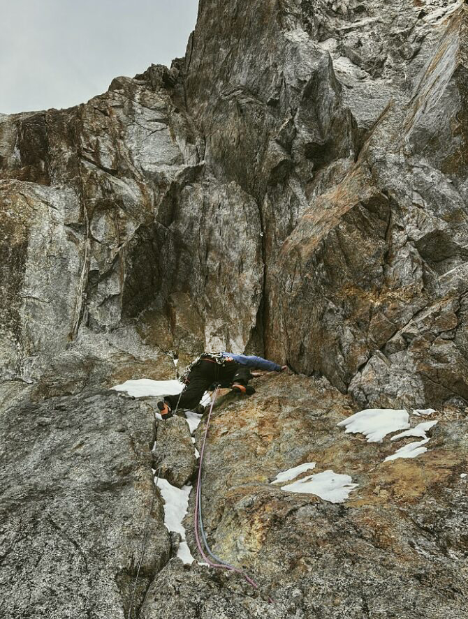 A climber on a mostly rocky, seriously overhanging pitch.
