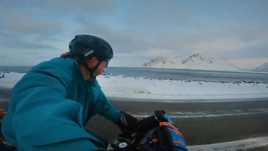 closeup of man on bike in muted arctic landscape