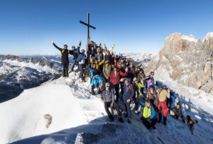 A group photo with the cross marking the summit of Cima Rosetta