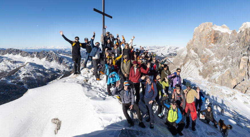 A group photo with the cross marking the summit of Cima Rosetta
