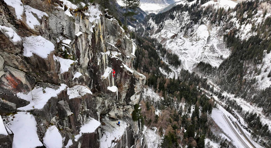 Two climbers in bright colored jackets on a mixed granite face.
