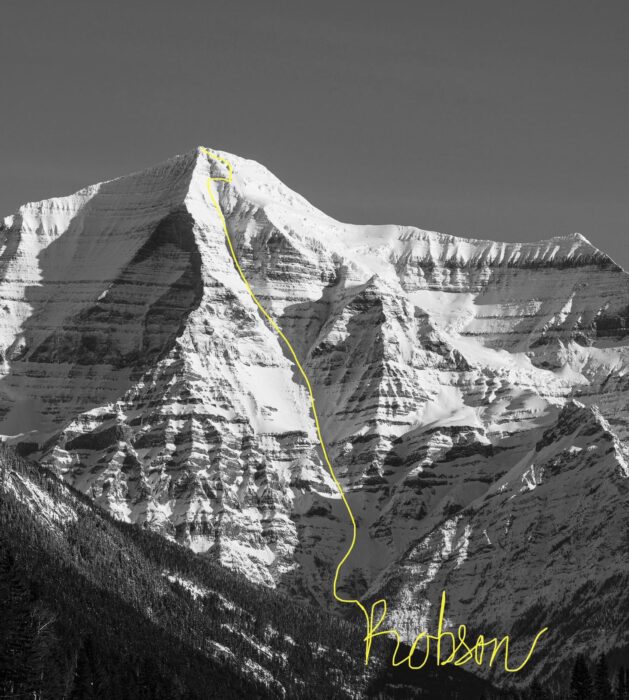 A black and white photo of the south face of Mount Robson with a yellow line marking a ski descent. 