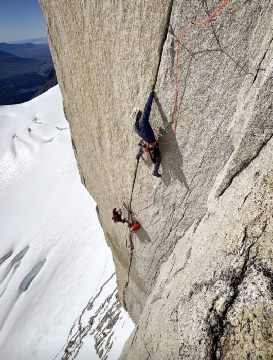 Two climbers on a vertical granite crack in Patagonia.
