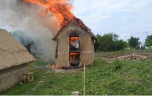 A wattle and daub house on fire.