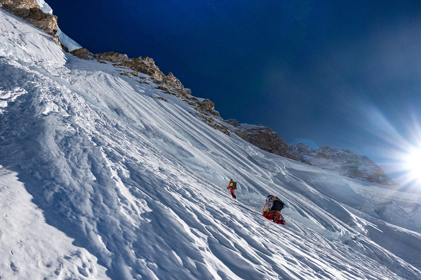 Climbers on fluted snow slope.