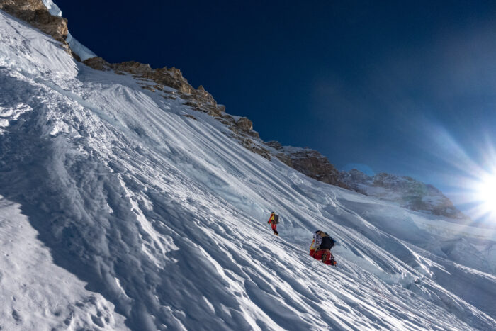 Climbers on fluted snow slope.