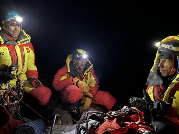 Climbers in the night with headlamps. 