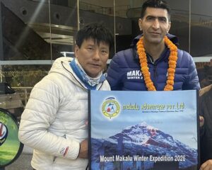 Climbers at the airport lobby holding a winter Makalu expedition banner.