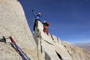 Two Nepalese climbers on a rocky ridge.