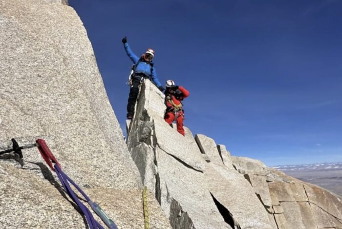 Two Nepalese climbers on a rocky ridge.