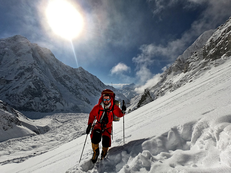 climber backlit on snow with sunstar