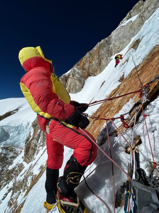 Climber at high altitude at a belay station. 