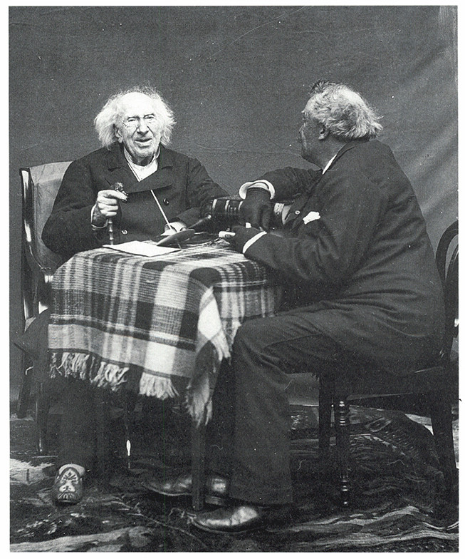 Two older men sitting together at a table.