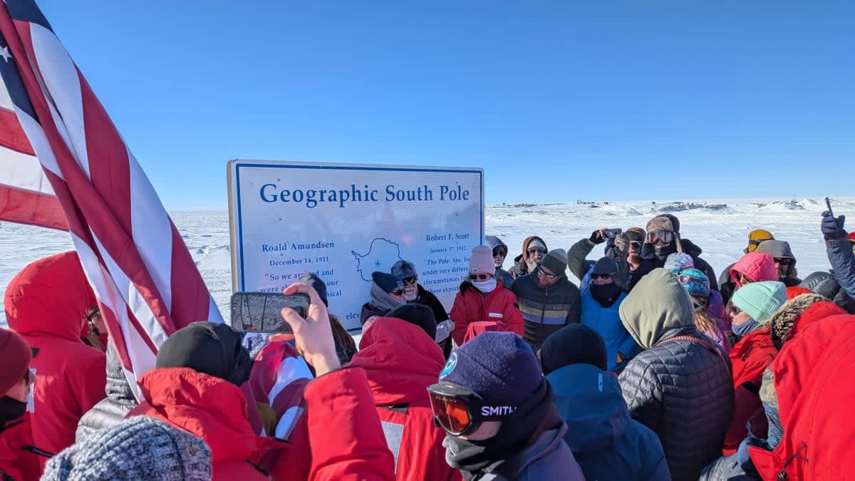 Station staff gather to place the 2026 geographic pole marker