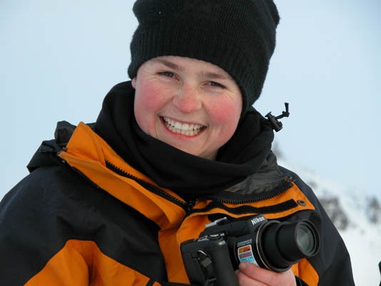 A smiling woman in a winter coat.