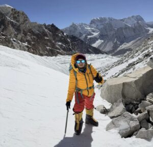 A climber on morain and hard-snow terrain.