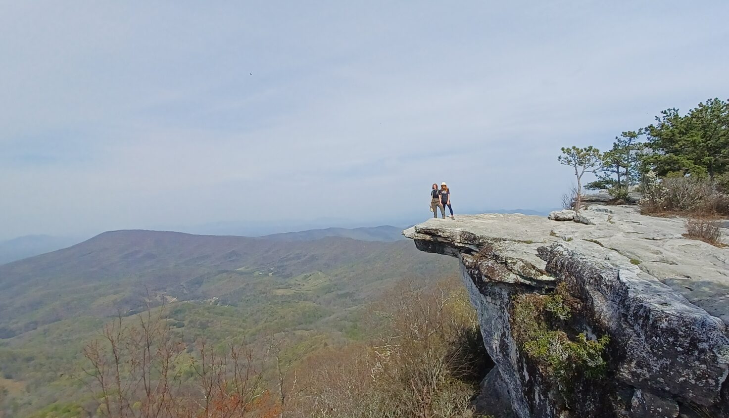 Two people standing on a rocky promontory.