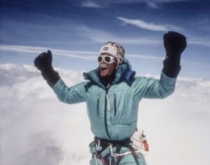 a man in a turquoise jacket cheering