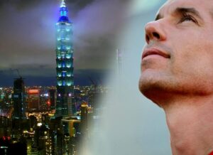 skyline of Taipei at night with portrait of Alex Honnold