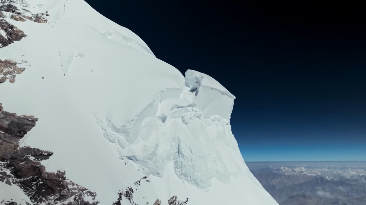 A small figure on a vast white mountainside
