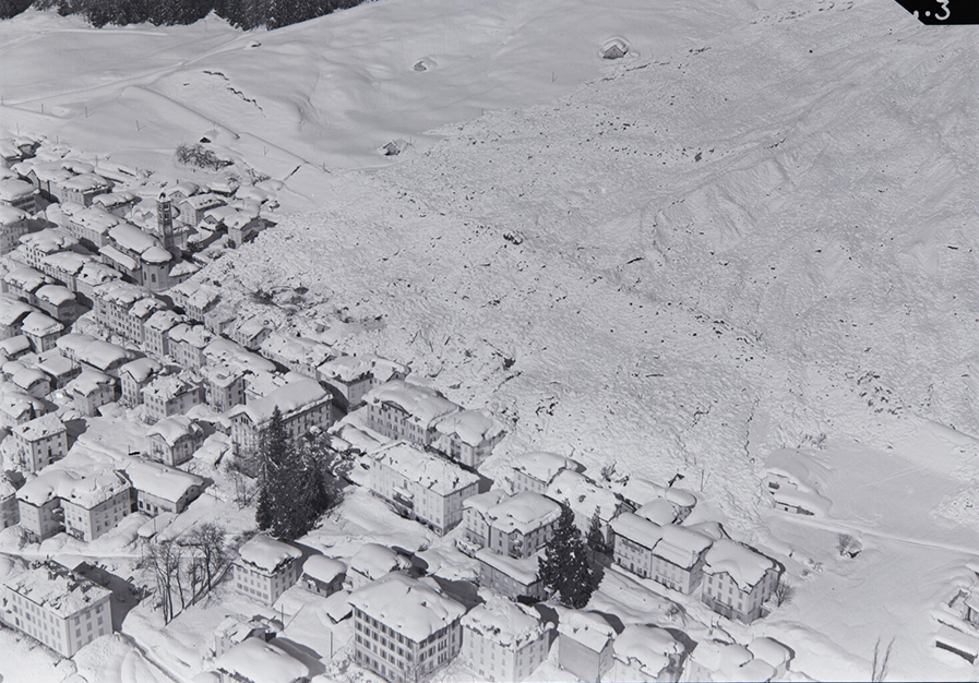 black and white photo of alpine town after avalanche