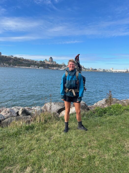 Kneip stands on the shores of the St Lawrence river with the buildings of Quebec City visible in the background