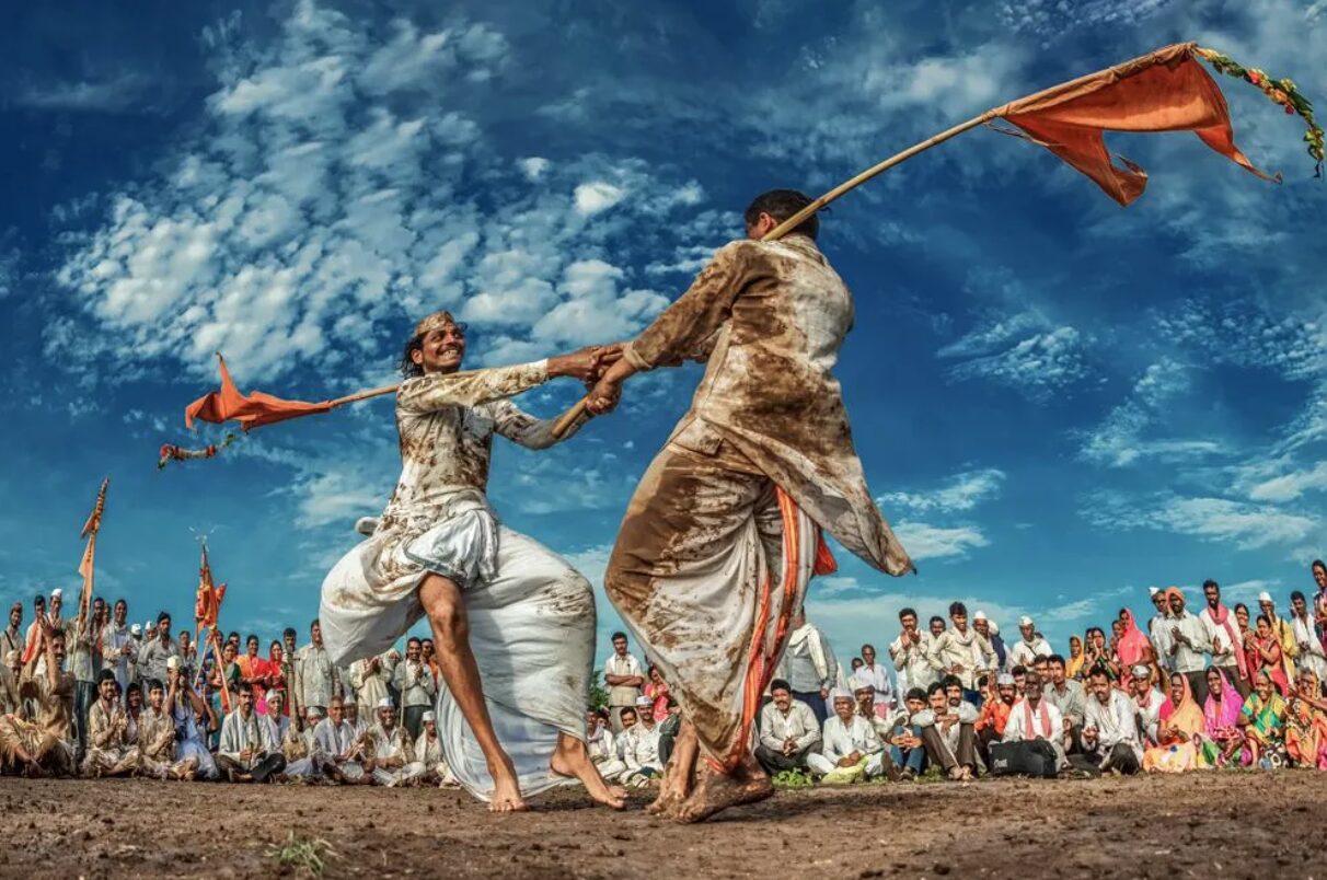 Two Warkari men perform a traditional dance in rural India.