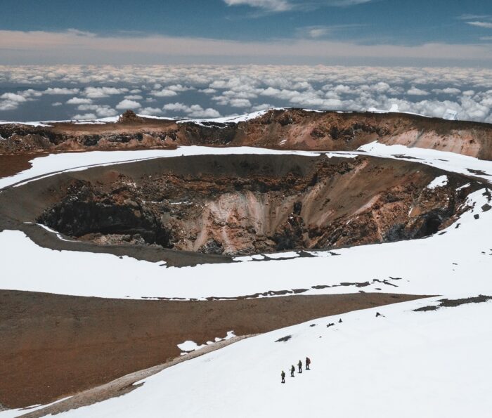 Climbers on a snow field by the summit crater of Kilimanjaro.