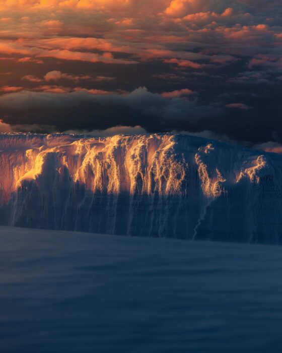 A glacier front on Kilimanjaro in dim, orange light. 