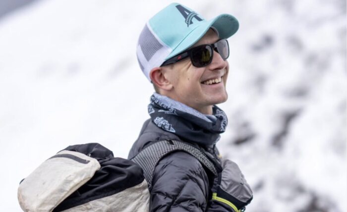 Close shot of Tyler Andrews with cap, sunglasses and a backpack.