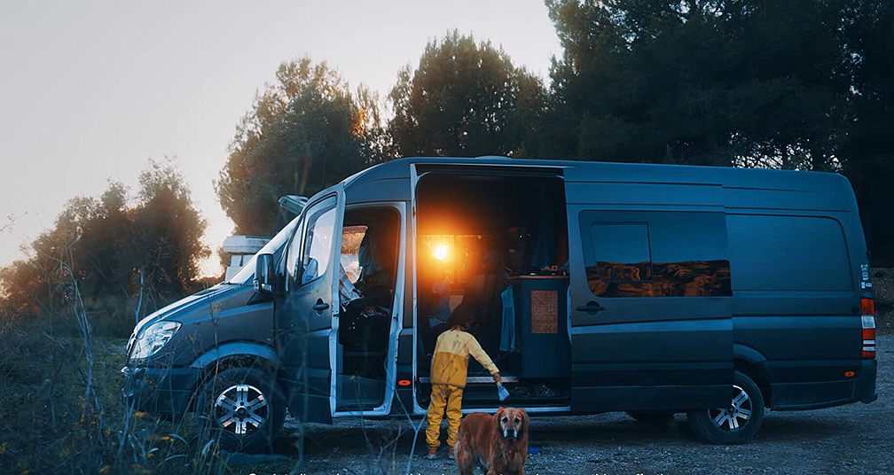 A large black van, with dog and child